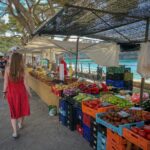 woman walking beside fruit and vegetable vendors