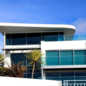 Sleek modern house with glass facade in Poole, UK under blue sky.