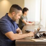 Two men working on devices in a modern office setting, emphasizing technology and collaboration.