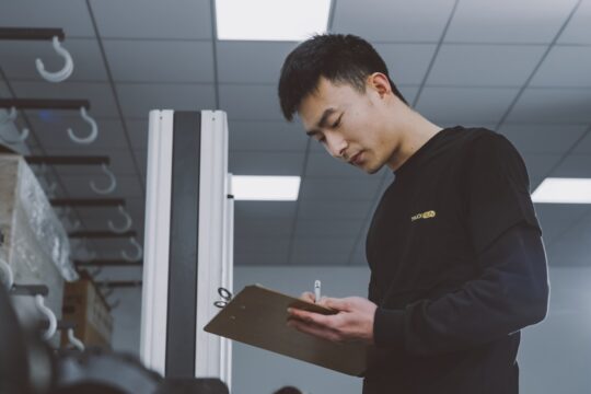 a man standing in a room holding a clipboard