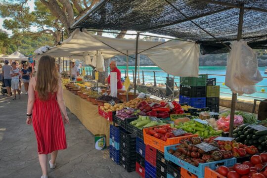 woman walking beside fruit and vegetable vendors