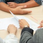 two people reviewing documents at meeting table
