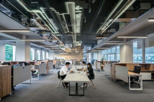 three people collaborating in open office