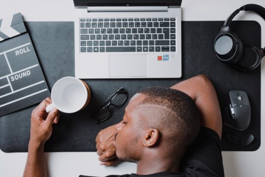 a man sitting at a desk with a laptop and headphones